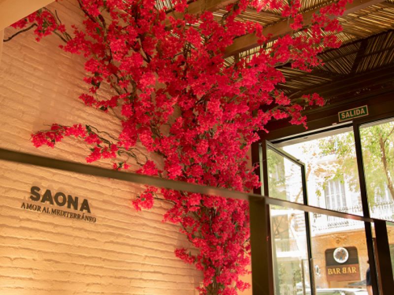 Greendecorum en Interior de Saona Restaurante con pared de ladrillo blanco, flores fuxia y techo con tiras de madera